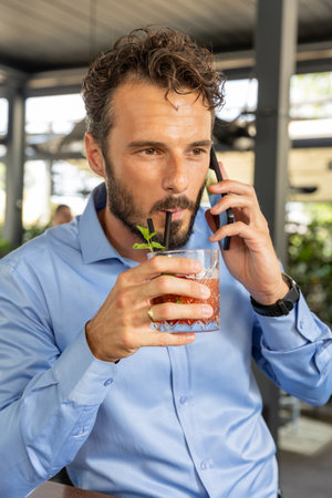 Man drinking cocktail alone in outdoor restaurantの写真素材