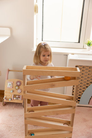 Toddler girl playing with the gravity wooden ball toyの写真素材