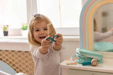 Little girl playing alone in the kindergarten with wooden toysの写真素材