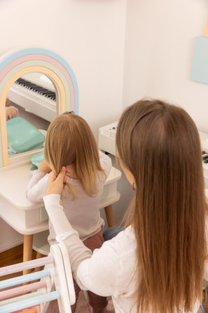 The mother is styling her daughter's hairの写真素材