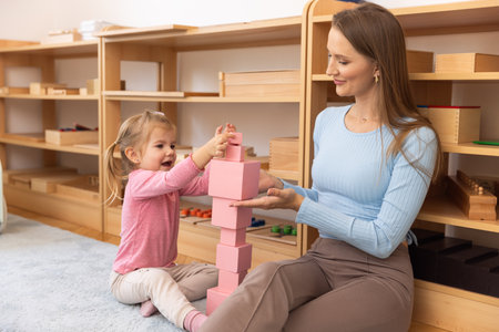 Mother and daughter playing together with wooden cubesの写真素材