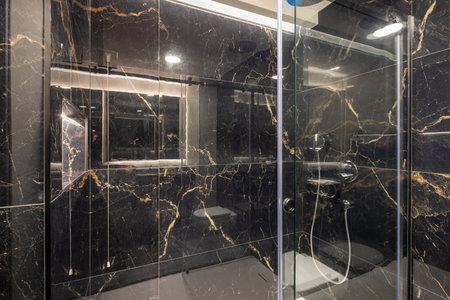 Bathroom interior with brown marble wall and glass shower cabinの写真素材