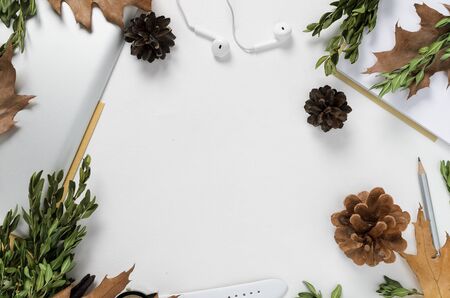 Workspace with tablet, pencil, green branches and pine cones on white background. top viewの写真素材