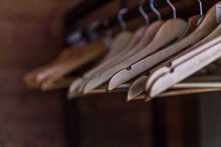 Clothes rail with hangers on blurred wooden background. Close up. Selective focusの写真素材