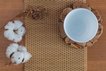 Empty cup on a wooden stand with cottonの写真素材