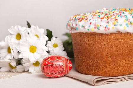 Easter cake and white flowers, red egg