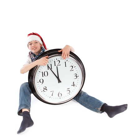 Teenager in cap of Santa Claus and large clock, isolation, studio