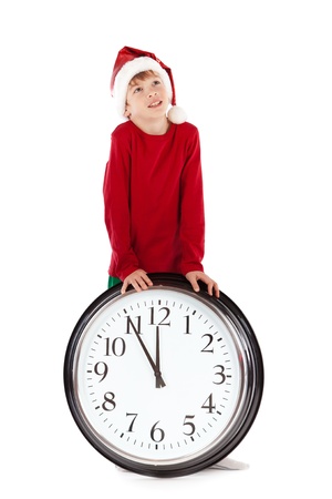 Boy in cap of Santa Claus and large clock, isolation, studioの写真素材