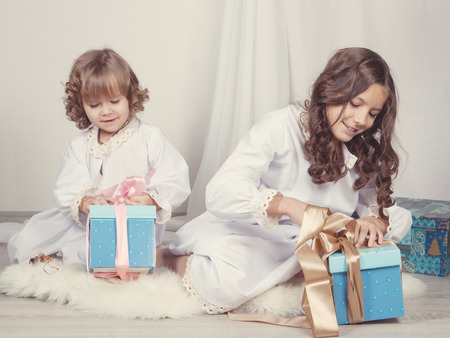 Girls watching Christmas gifts, indoorの写真素材