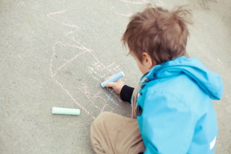 Boy drawing on road. Outdoor.の写真素材