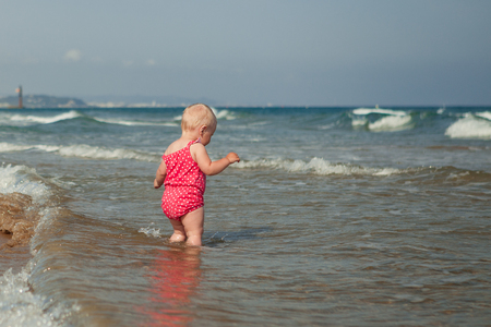 Adorable little girl walking along beachの写真素材