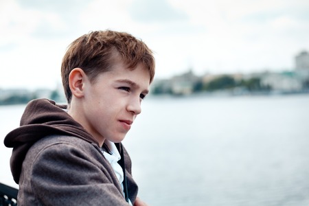 Portrait of teenager on background of river, outdoor