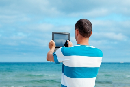 Portrait of man using tablet computer in  coastline,の写真素材
