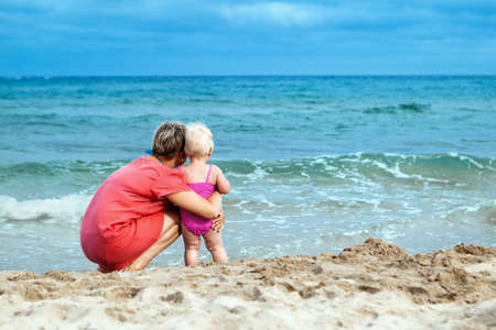 mother and his adorable little daughter at beachの写真素材