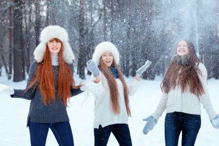 Portrait of three  happy beautiful girls in winter parkの写真素材
