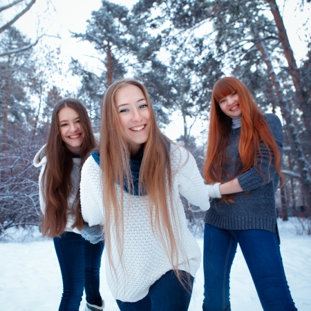 Portrait of three  happy beautiful girls in winter parkの写真素材