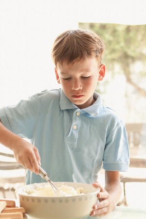 boy makes a cake in kitchen, indoorの写真素材