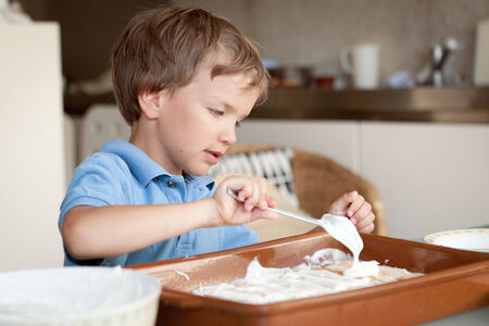  Small boy makes a cake in kitchenの写真素材