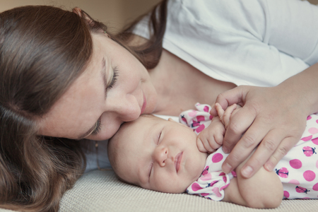 Happy mother hugging her little daughter, baby, newborn, tenderness and love, indoorの写真素材