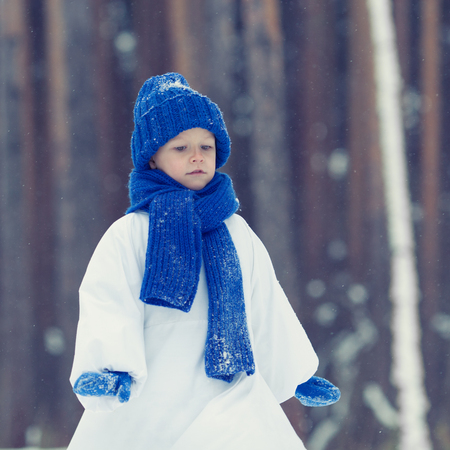 Happy boy in costumes snowman walking in winter forest, outdoorの写真素材