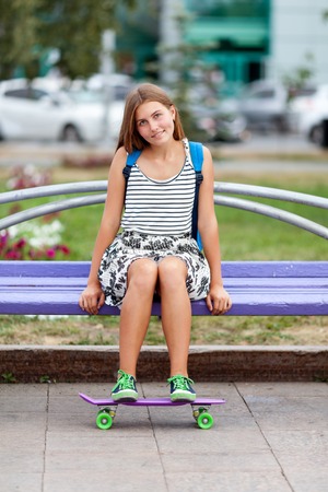 Beautiful, happy and fashion young woman posing with skateboard, summer, urban, outdoorの写真素材
