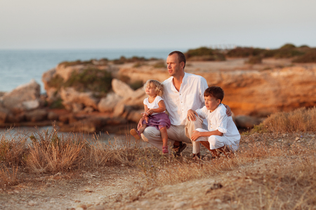 Portrait of cheerful happy father, son and small daughter on background of sea, Spainの写真素材