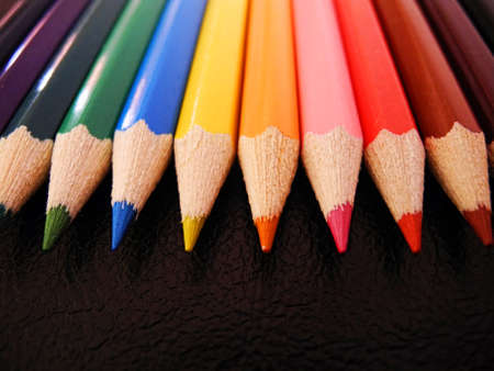 wooden crayon pencils  arrangein line on a leather surface