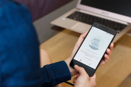 SAN FRANCISCO, US - 22 April 2019: Close up to female hands holding smartphone using Android Things ToolKit Service, San Francisco, California, USA. An illustrative editorial image.のeditorial素材