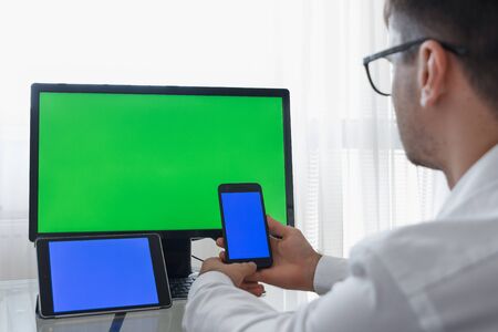 Engineer, Constructor, Designer in Glasses Working on a Personal Computer with a Green Screen on...