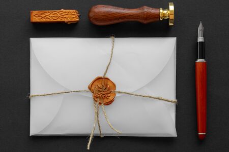 Notary public wax stamper. White envelope with brown wax seal, golden stamp. Responsive design mockup, flat lay. Still life with postal accessories.の写真素材