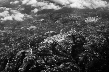 Aerial view from the plane on the panorama of the city through the clouds. View from above on the...