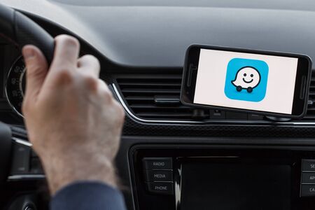 LOS ANGELES, CALIFORNIA - JUNE 6, 2019: Close up to male driving and using navigation application....