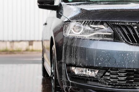 Water drops and foam on the car light in the vehcle wash station. Cleaning automobile concept, underground water pollutionの写真素材