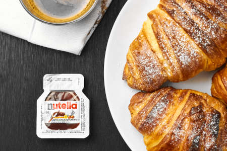 Freshly baked croissants with nutella and a cup of coffee on a black background. Perfect breakfast concept. Homemade pastry.のeditorial素材