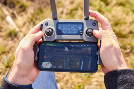 Close up mans hands holding a drones remote controller. A aerial shoot of a bridge is on the screen of smartphone. Real footage concept. Liberec, Czech Republic, May 2020のeditorial素材