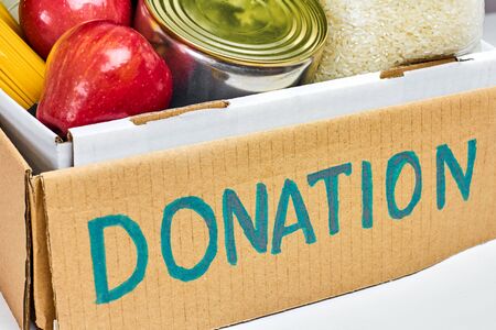 Close up a cardboard box with food for donation. Charity concept.