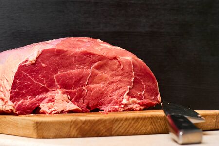 Raw fresh beef meat and knife on a black background. Healthy dinner receipt conceptの写真素材