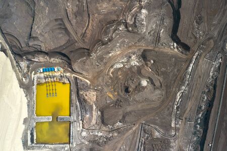 Top view on a pool with yellow liquid used in a coal mining in a quarry. Heavy industry concept