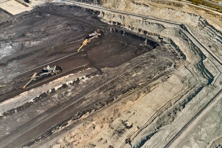 Aerial shoot of quarry with heavy bucket wheel excavators mining a coal. Heavy industry concept.