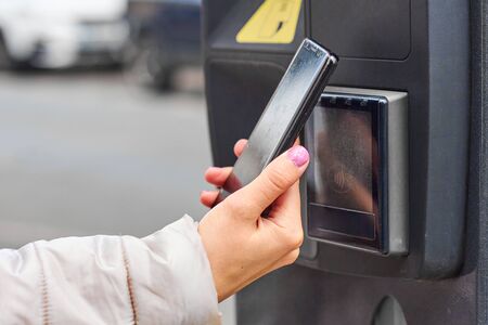 Smartphone payment with NFC technology for public parking with copy space. Contactless payment...