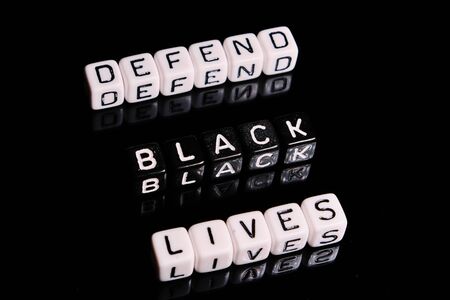 Defend black lives text on a black background. BLM in support of African Americans peopleの写真素材
