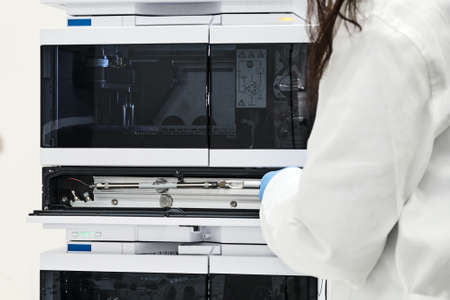 Chemist or scientist changing a column on high performance liquid chromatography HPLC for separation...