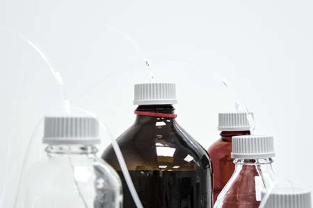 Bottles with mobile phase for high performance liquid chromatography. HPLC system for separation of...