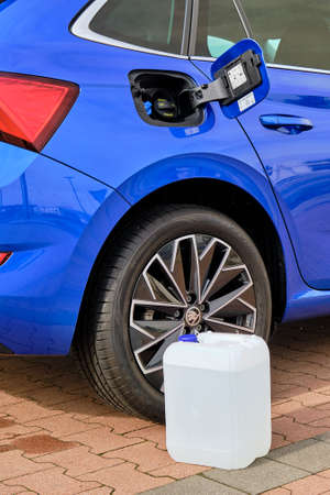 Close up a white canister with a diesel exhaust fluid near the wheel of blue Skoda automobile. Ad Blue liquid for reduction of air pollution, October 2020, Prague, Czech Republic.のeditorial素材