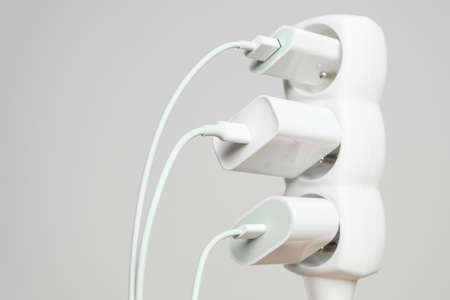 Indoor white office extension cord with three white connected to it power plugs with copy spaceの写真素材