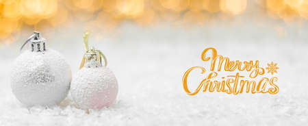 Modern Merry Christmas greeting card with balls on the snow and blurred lights on the background in orange styleの写真素材