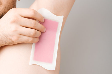 Man remove hair using wax strip from armpit. Unshaved armpits or underarm. Depilation and hair remove procedure. Body shaming concept.の写真素材