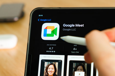 Google Meet logo shown by apple pencil on the iPad Pro tablet screen. Man using application on the tablet. December 2020, San Francisco, USA.のeditorial素材