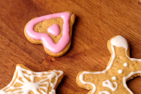 A gingerbread man and heart cookies on the wooden background.