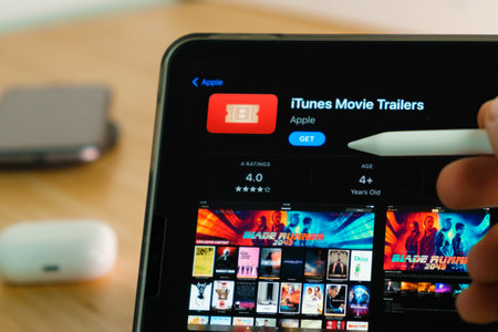 iTunes Movie Trailers logo shown by apple pencil on the iPad Pro tablet screen. Man using...